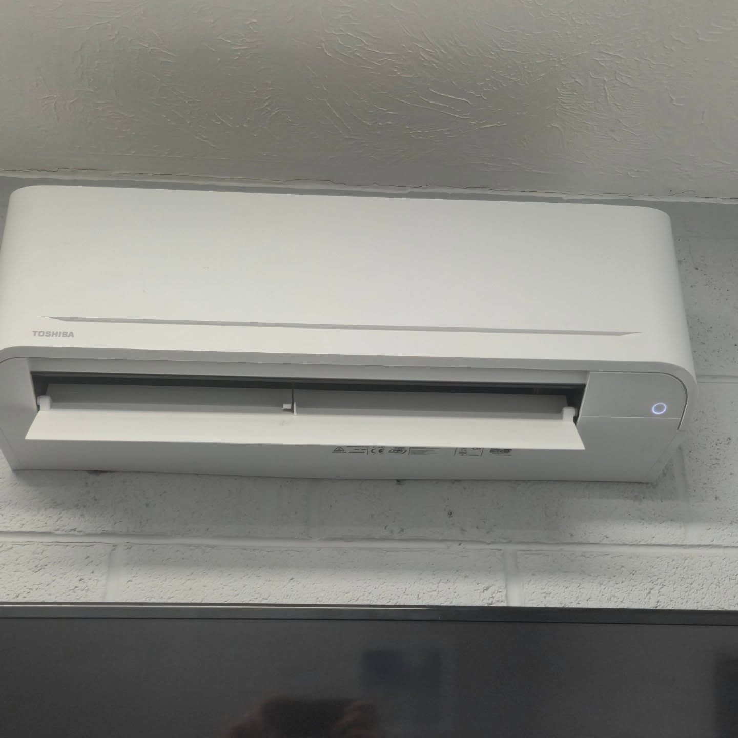 Toshiba wall-mounted air conditioning and heating unit installed indoors