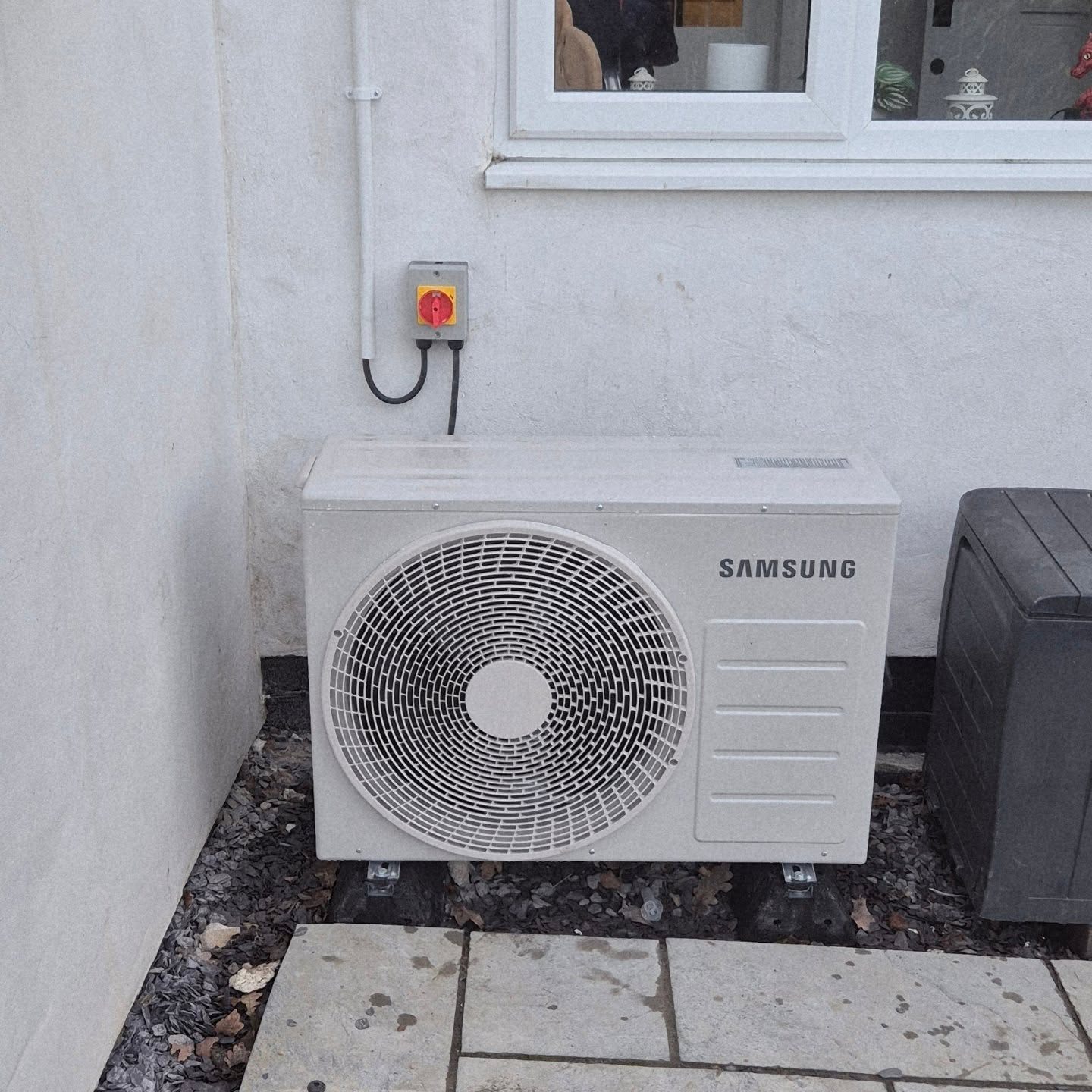 Samsung air-to-air heat pump outdoor unit installed below a window